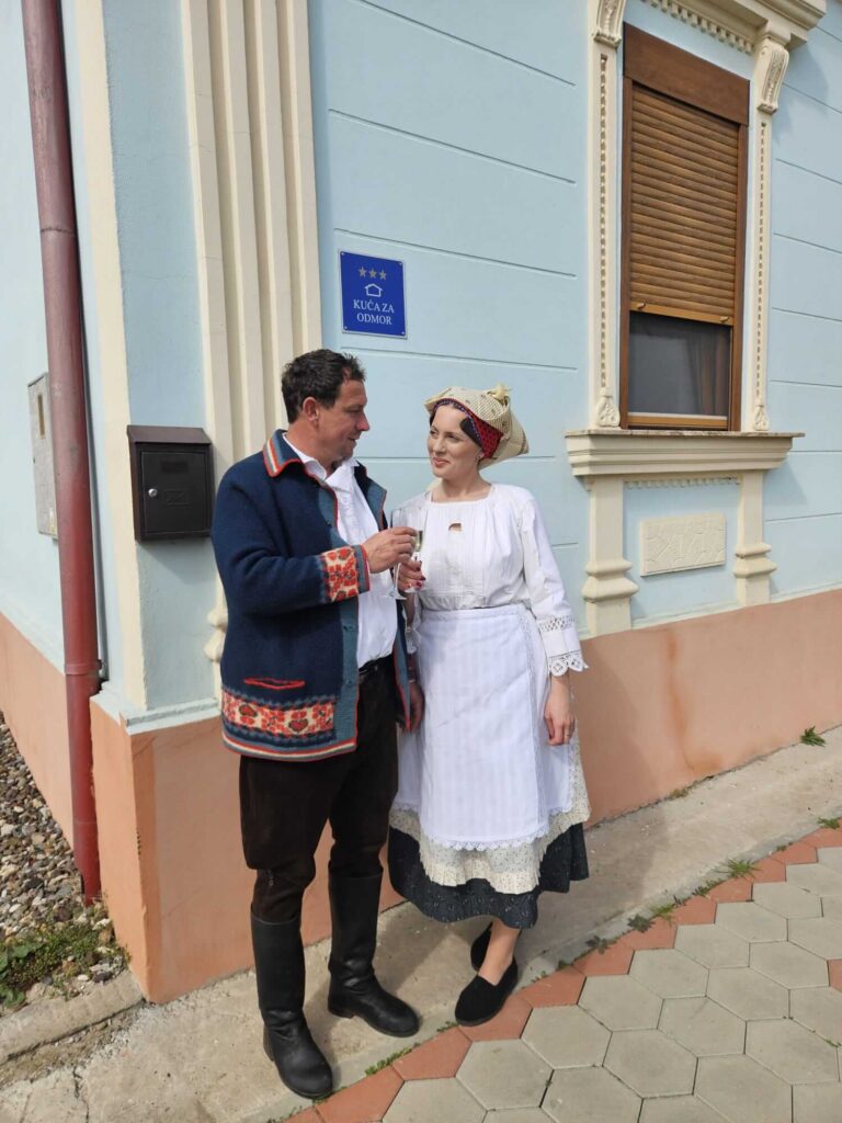 Marija i Stjepan obučeni u slavonsku narodnu nošnju ispred svoje kuće za odmor