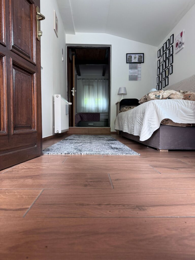 predsoblje apartmana Djed gdje je kauč prekrivren bijelom prostirkom, vrata u glavni prostor te smeđa drvena ulazna vrata