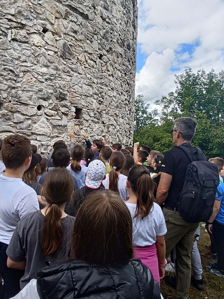 skupina djece osnovne škole s voditeljem radionice promatraju Čuntić kulu na Banovini